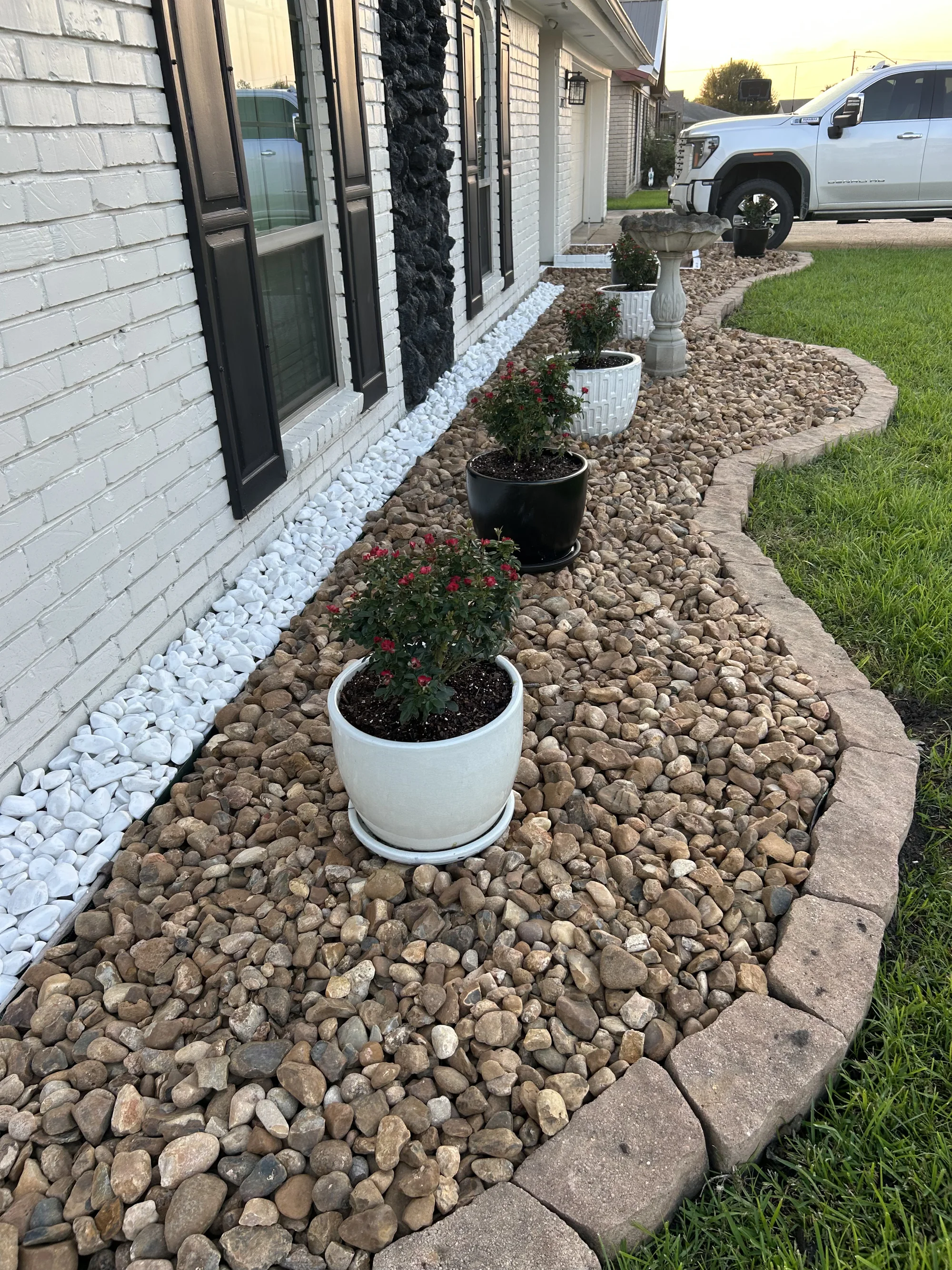 River rock garden bed with planters and stone edging
